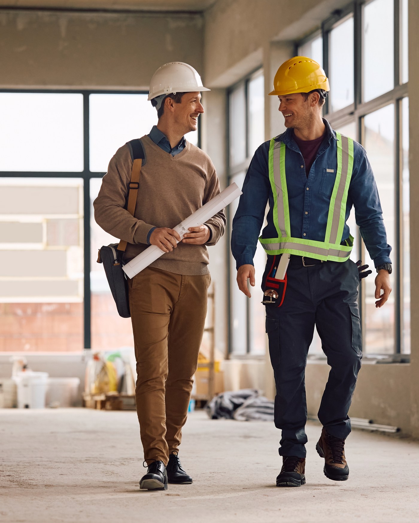 A construction site inspector talking with a worker on-site.